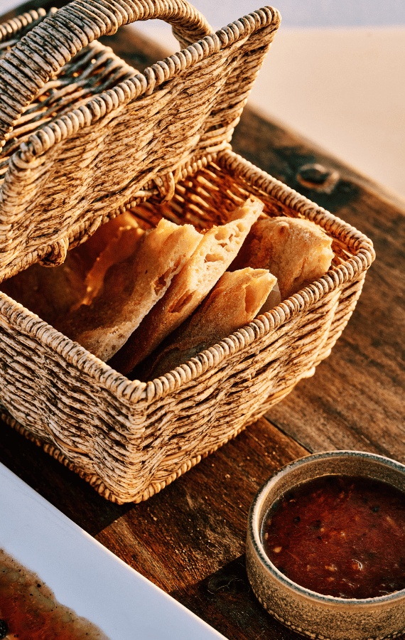 Basket of freshly baked flatbread served with a Mediterranean dipping sauce at Sunsets Santorini