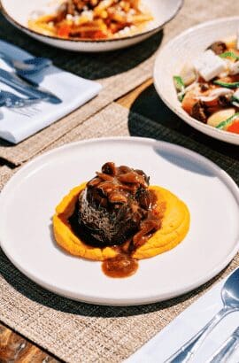 Gourmet beef fillet with rich sauce over purée, served at Sunsets Terra in Santorini with Mediterranean sides