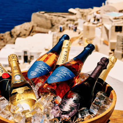 Assortment of chilled sparkling wines and rosé bottles in ice at Bites & Bubbles by Sunsets with caldera view
