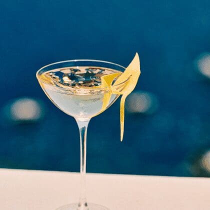 Signature cocktail with lemon twist served at Bites & Bubbles by Sunsets overlooking the Aegean Sea