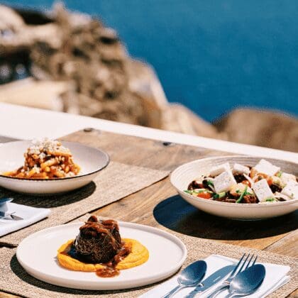 Gourmet lunch at Sunsets Santorini with beef fillet, Greek salad, and pasta served on a terrace overlooking the Aegean