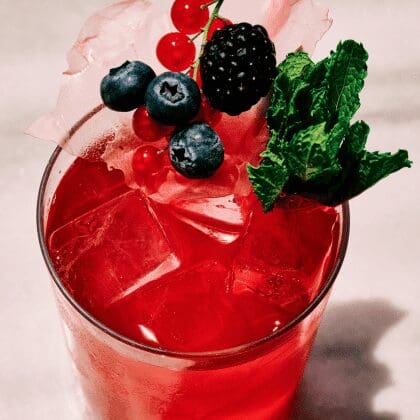 Vibrant berry cocktail with mint and ice served at Bites & Bubbles by Sunsets in Santorini