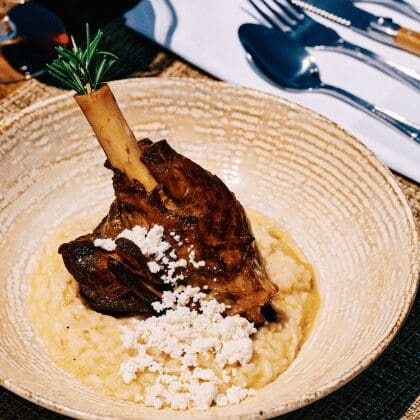 Slow-cooked lamb shank with creamy risotto and crumbled feta, served at Sunsets Terra in Santorini