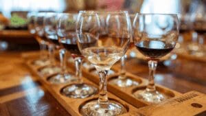 Wine tasting flight with red and white wines arranged on a wooden tray during a Santorini winery experience.