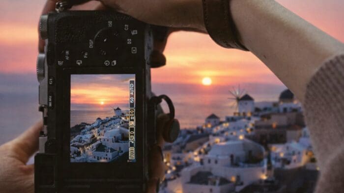 woman photographing the santorini sunset in Oia