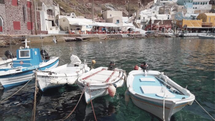 Small fishing boats at Ammoudi Bay in Oia Santorini, one of the must-see attractions below the caldera cliffs