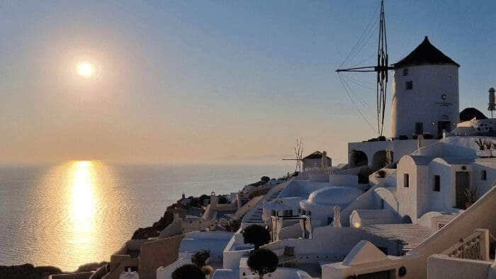 Oia Santorini windmill at sunset with whitewashed houses and caldera views over the Aegean Sea