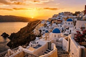 Proposal dinner table for two set on a caldera-view terrace in Oia, Santorini, at golden hour