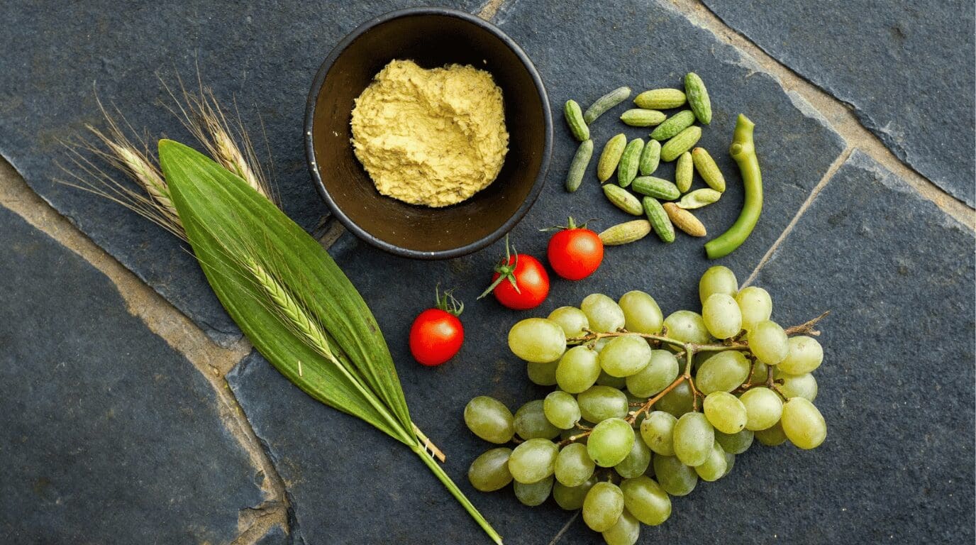 Santorini volcanic-soil ingredients including cherry tomatoes, fava, and capers arranged on a rustic surface