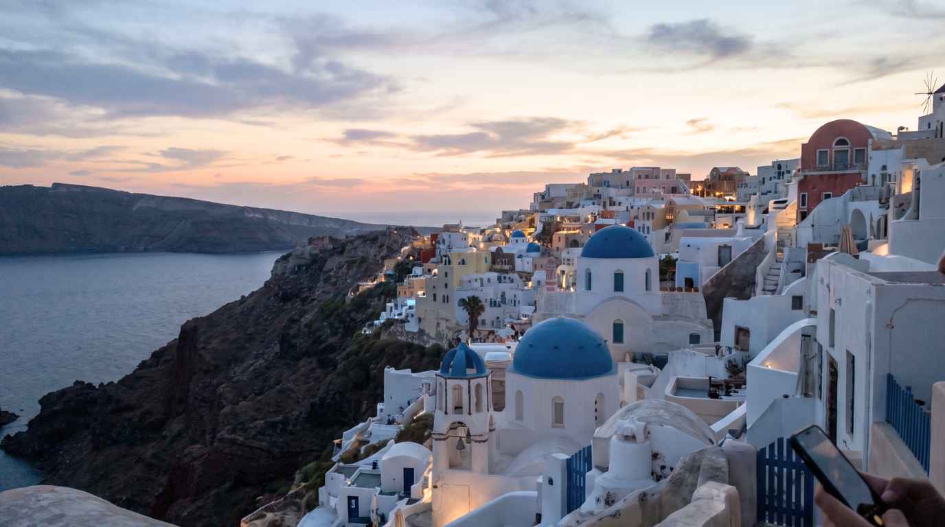 Oia village and the Santorini caldera at dusk, seen from the castle end of the village
